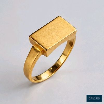 gros plan d'une bague en or sur une surface blanche