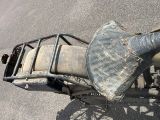 une vieille moto équipée d'une selle et d'un porte-bagages arrière