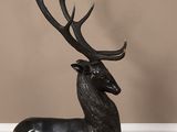 an image of a statue of a stag sitting on a wooden floor