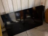 une télévision à écran plat posée par terre dans un coin de la pièce