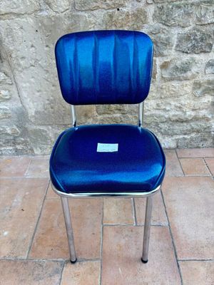 a blue chair that is sitting on a tile floor