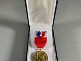 an image of a medal in a box with a ribbon around it