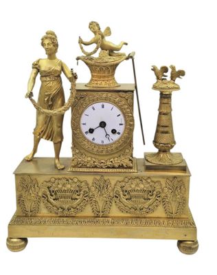 une horloge en or surmontée d'une statue