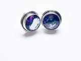 gros plan d'une paire de boucles d'oreilles sur une surface blanche