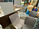 a lot of chairs and a table in a warehouse