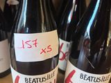 several bottles of wine on a shelf with a price tag on them