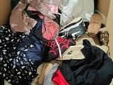 a cardboard box filled with clothes and a pair of shoes