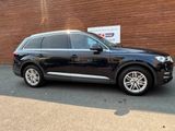 Le SUV Audi noir est garé devant un immeuble.