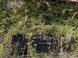 an old suitcase sitting in the weeds next to a building