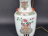 a white vase with pink flowers on it on a table