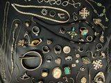 many different types of jewelry displayed on a black surface
