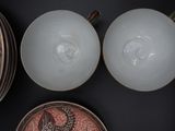 two bowls and a plate on a black table
