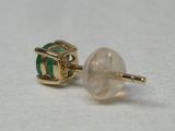 une paire de boucles d'oreilles à clous rayées de vert et de blanc sur un fond blanc