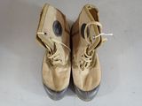 pair of brown shoes with laces on them sitting on a white surface