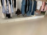 un portant de vêtements posé sur une étagère dans une pièce
