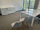 deux chaises et une table dans une pièce dotée d'une grande fenêtre