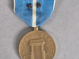 an old medal with a blue and white ribbon on a gray surface