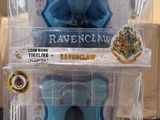 trois figurines Harry Potter dans leur emballage en plastique, posées sur une table