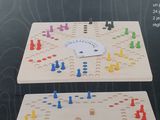two wooden board game pieces with colorful pieces on them in a box
