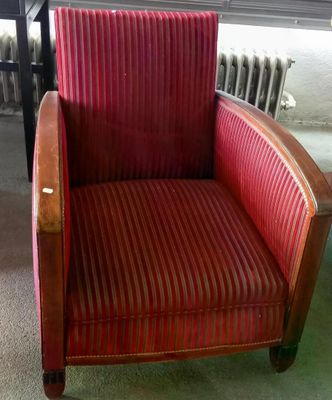 une chaise rouge qui se trouve dans une pièce avec un radiateur en arrière-plan
