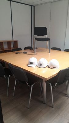 une table en bois sur laquelle sont posés des casques de chantier