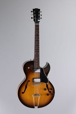 un gros plan d'une guitare posée sur un support, sur fond blanc