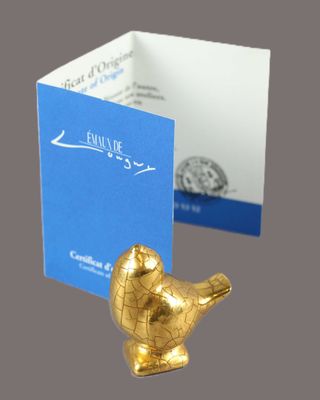 a gold bird figurine next to a business card holder