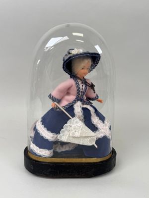 une figurine représentant une femme en robe bleue, placée sous un dôme en verre