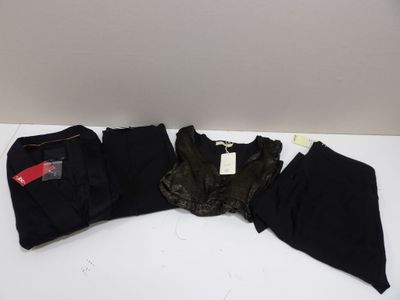 trois paires de pantalons noirs et un pantalon noir posés sur une table