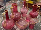 beaucoup de vases et de verres en verre rose posés sur une table