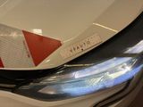 a close up of a car ' s headlight with a sticker on it
