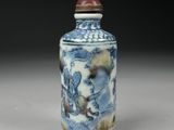 a small blue and white vase with a red lid