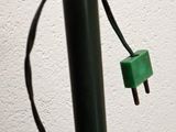 a black pole with a green light attached to it
