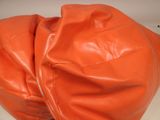 an orange bean bag sitting on top of a white table