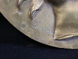 a bronze statue of a woman with long hair