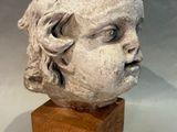 an image of a sculpture of a child ' s head on a wooden block