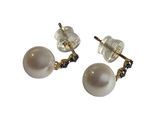 une paire de boucles d'oreilles en perles et diamants noirs sur fond blanc