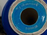 a blue vase sitting on a table with writing on it