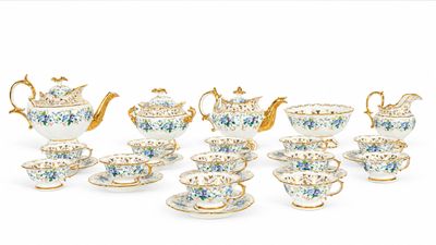 de nombreuses tasses, soucoupes et théières sur la table