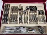 a tray with silverware in it on a table