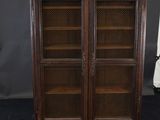 an antique wooden cabinet with glass doors and shelves