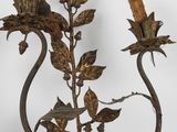 a metal candle holder with two flowers on it