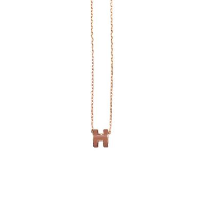a gold necklace with a letter h on a chain