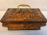 an old wooden box with a handle on a white surface