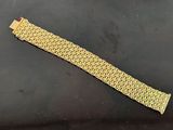 a close up of a gold bracelet on a black surface