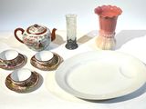 une table sur laquelle se trouvent une assiette, des tasses et un vase