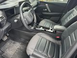 the interior of a car with the door open and the driver ' s seat down