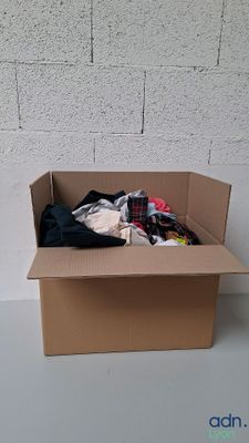 une boîte en carton contenant des vêtements, posée sur une table