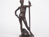 statue en bronze représentant un homme tenant une épée et un poisson