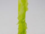 a green glass vase with a flower inside of it